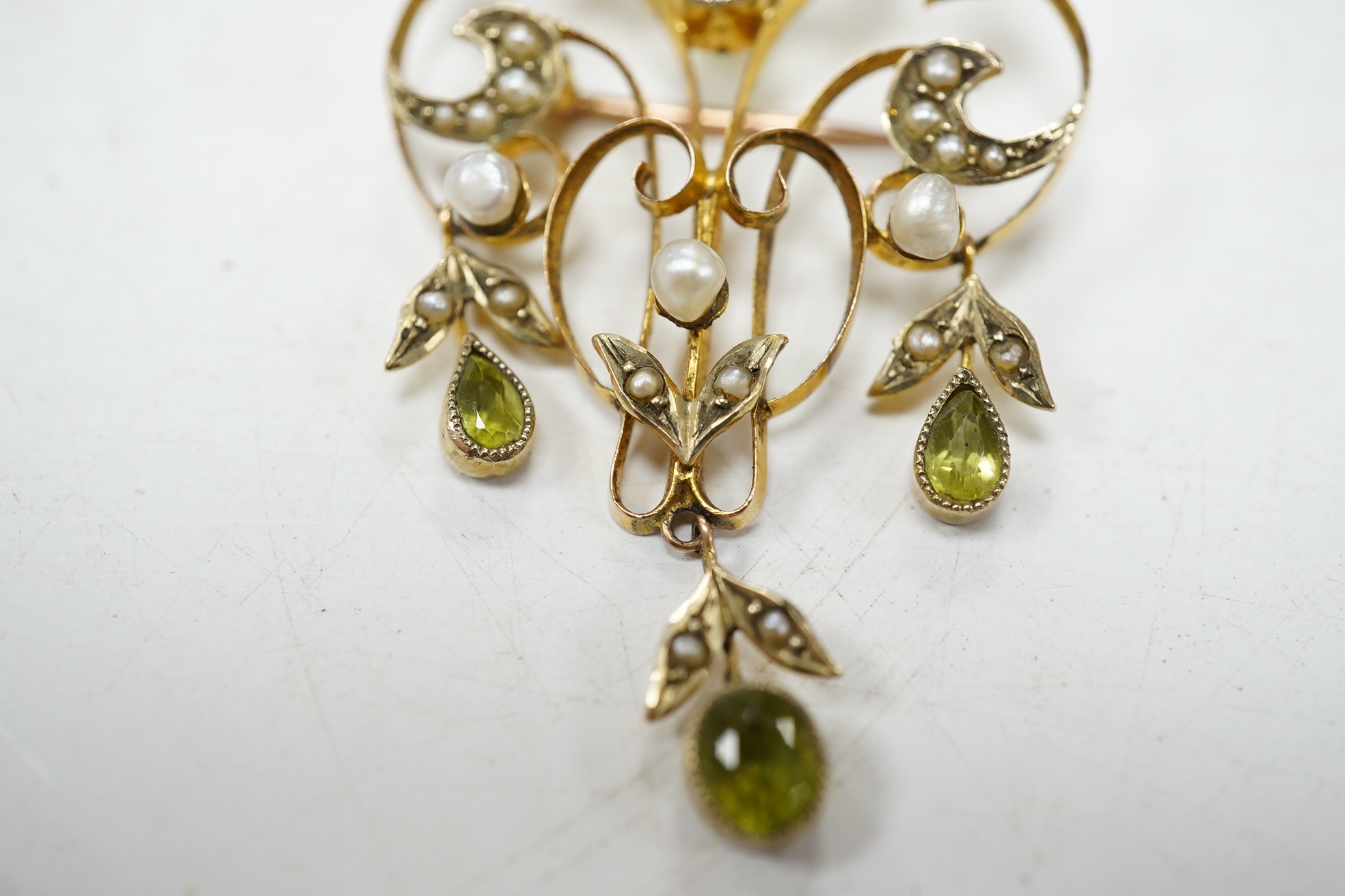 An early 20th century 9ct, peridot and seed pearl cluster set drop pendant brooch, 53mm, gross weight 5 grams. Condition - fair